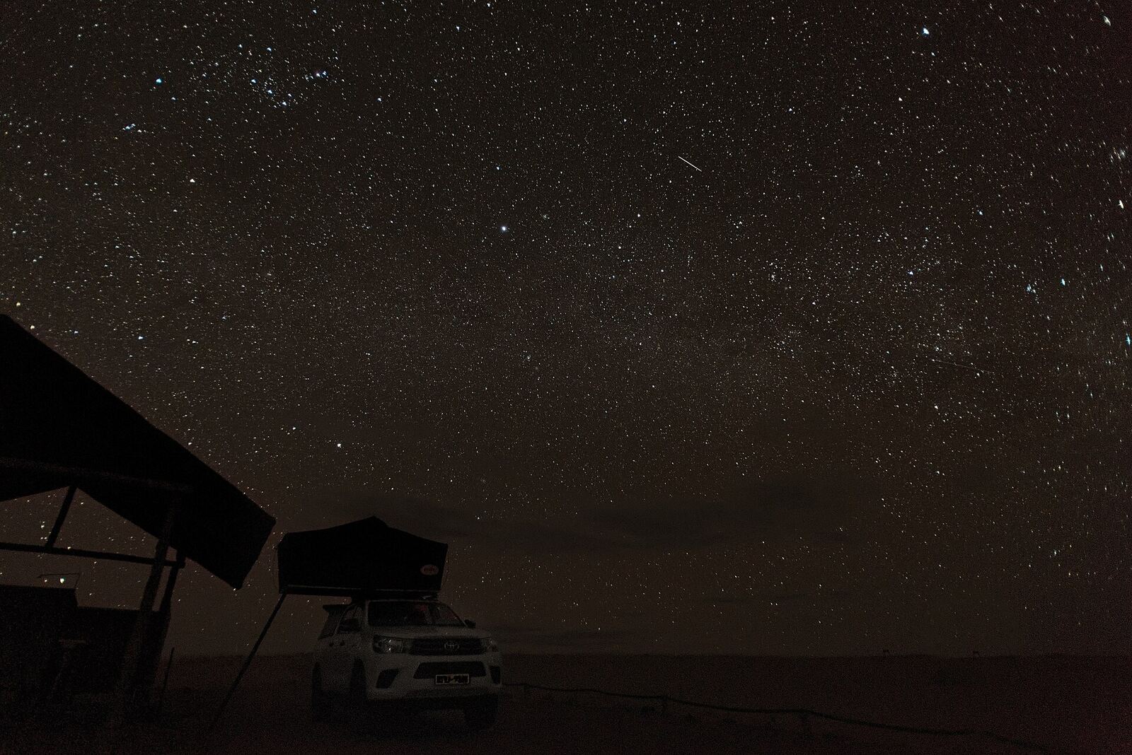 Clear night sky above a remote lodge or desert setting