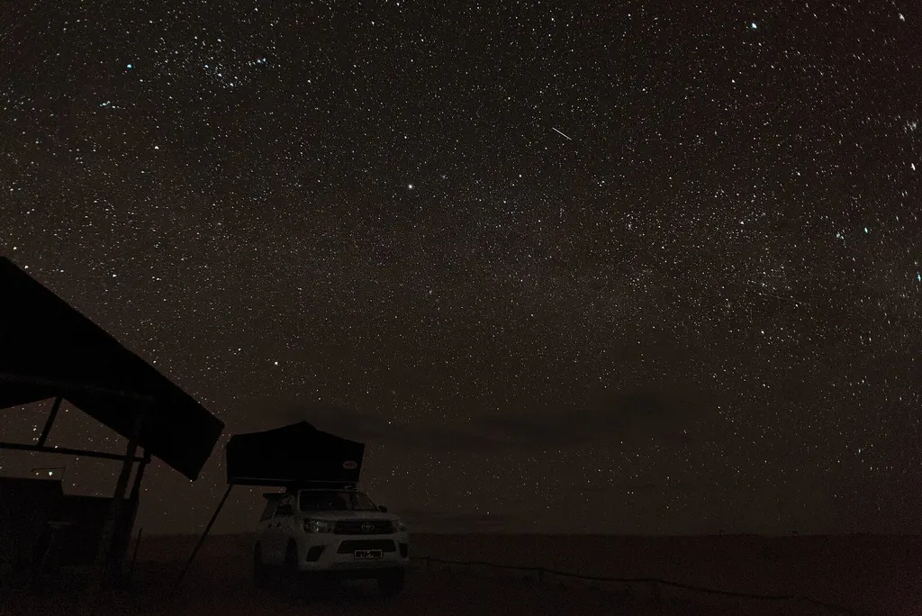 Clear night sky above a remote lodge or desert setting